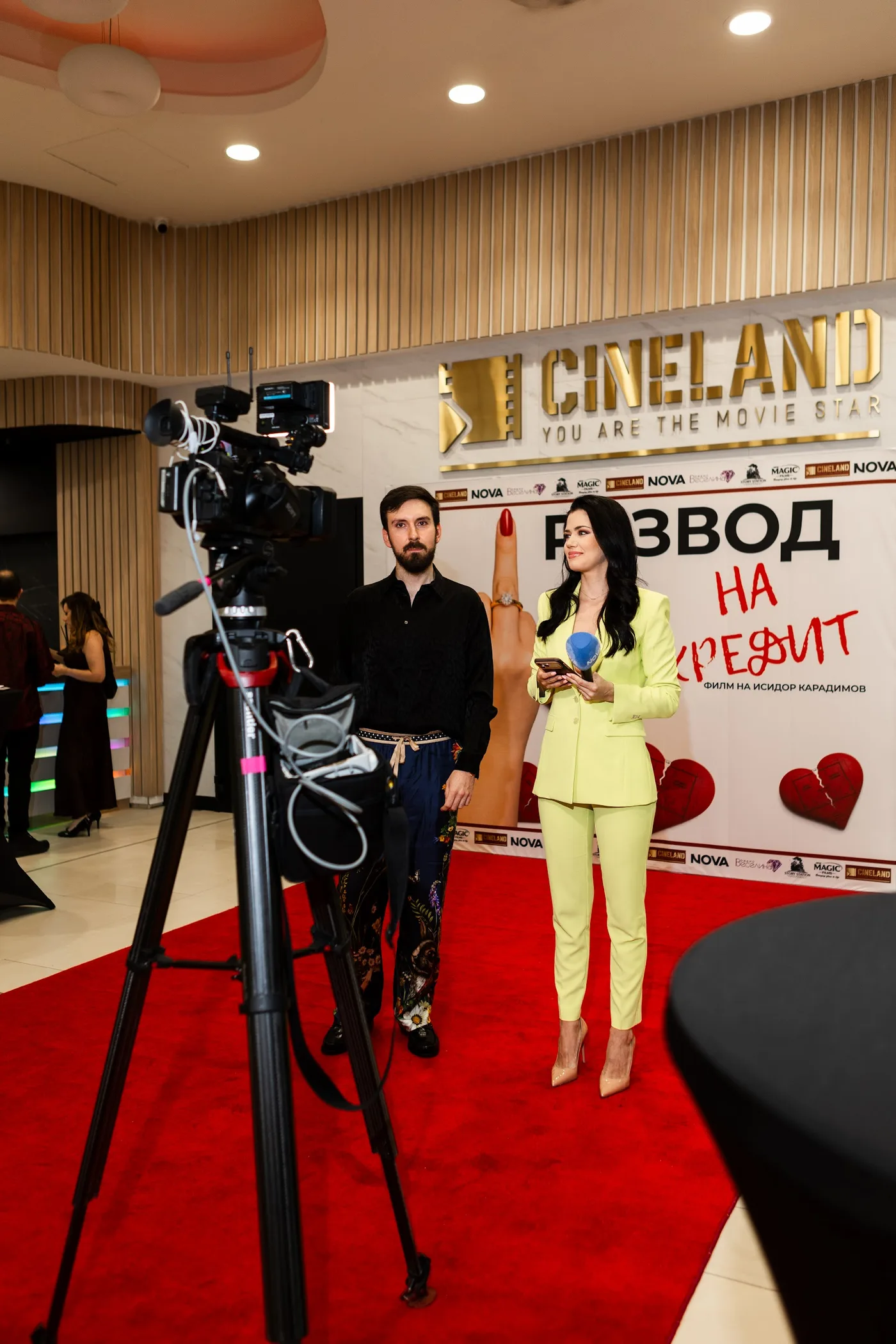 A camera captures the premiere atmosphere — Divorce on Credit gala premiere, July 23, 2026.