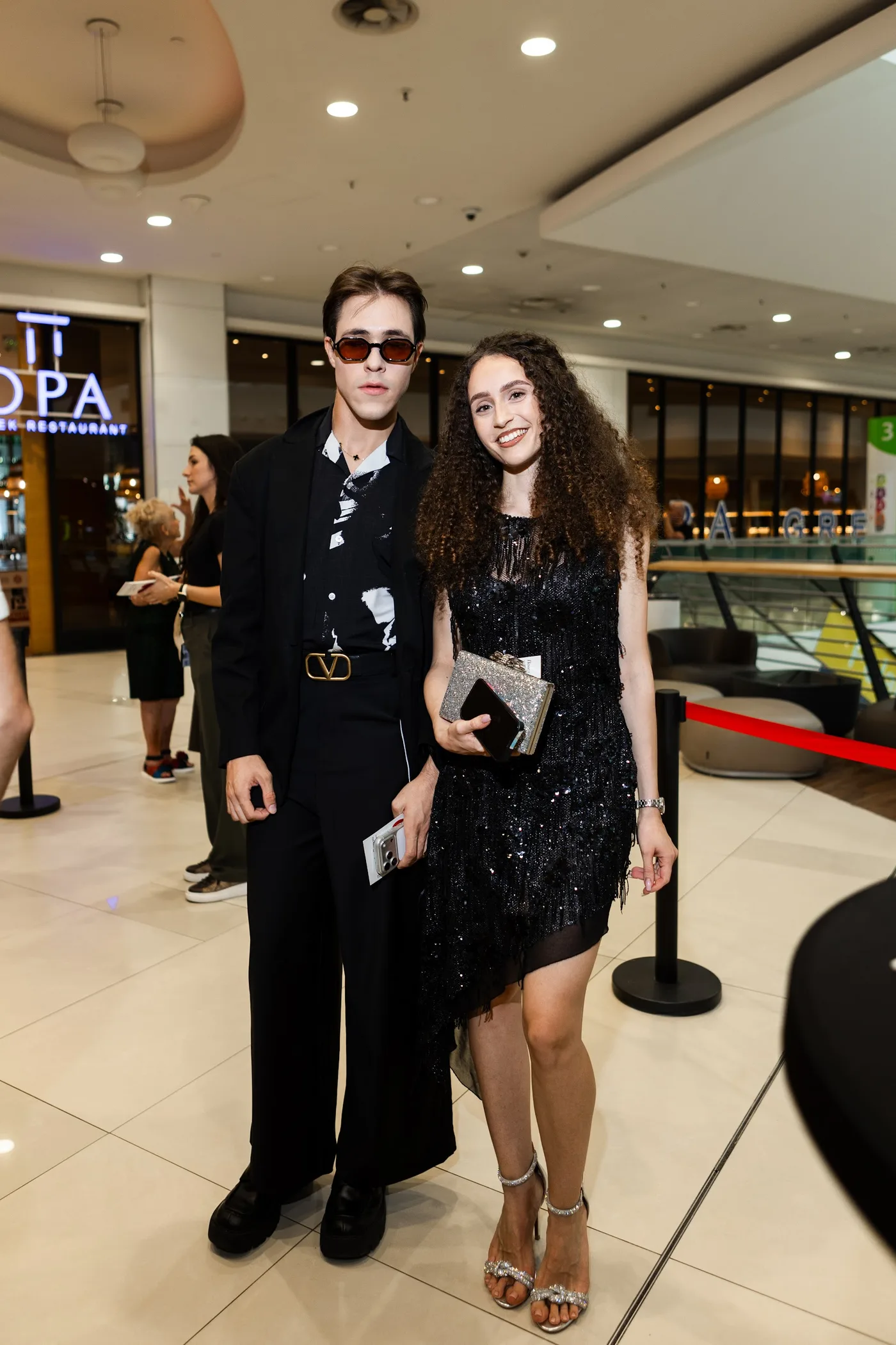 Two guests in the cinema foyer — Divorce on Credit gala premiere, July 23, 2026.