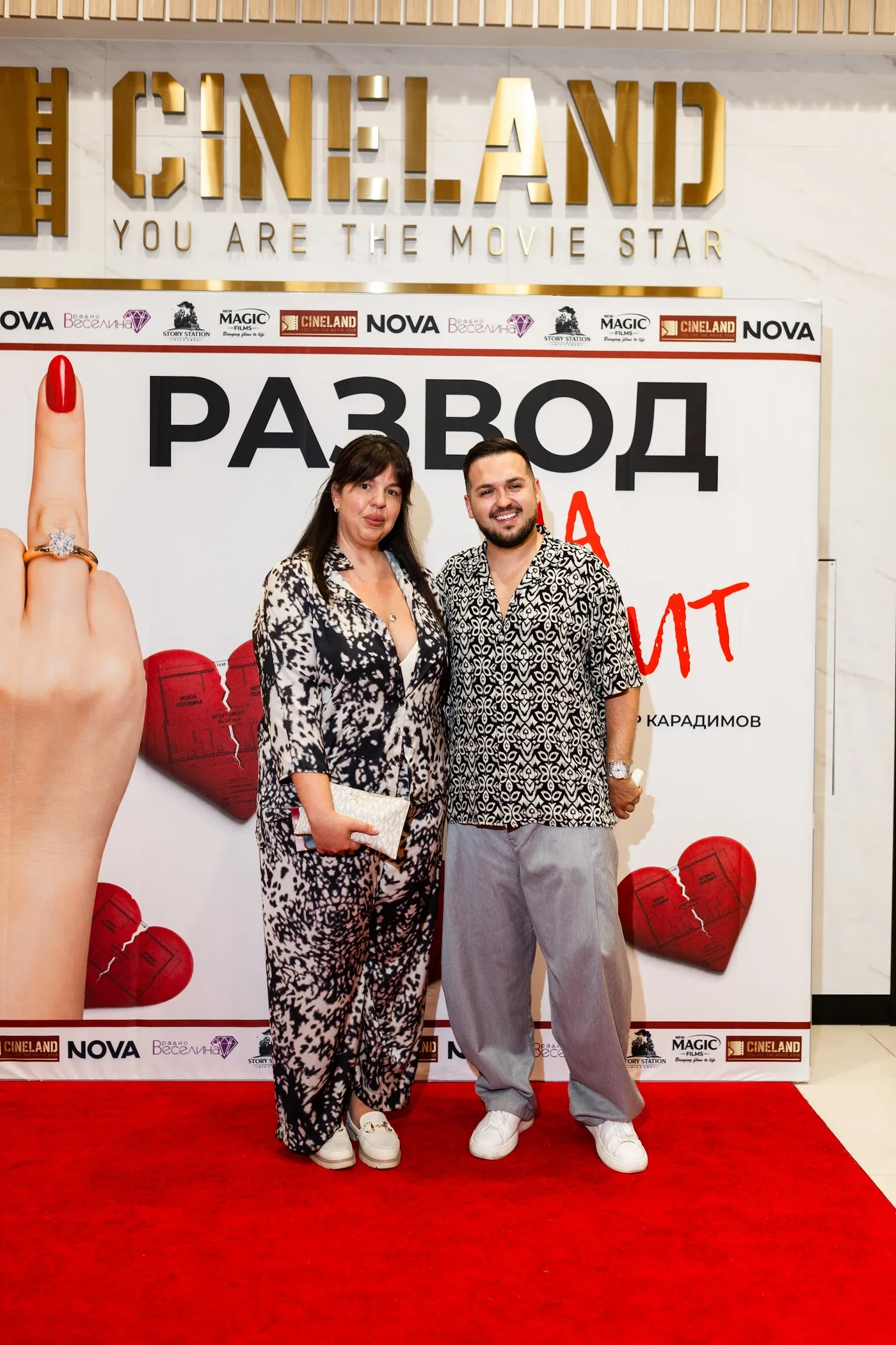 Two guests at the premiere backdrop — Divorce on Credit gala premiere, July 23, 2026.